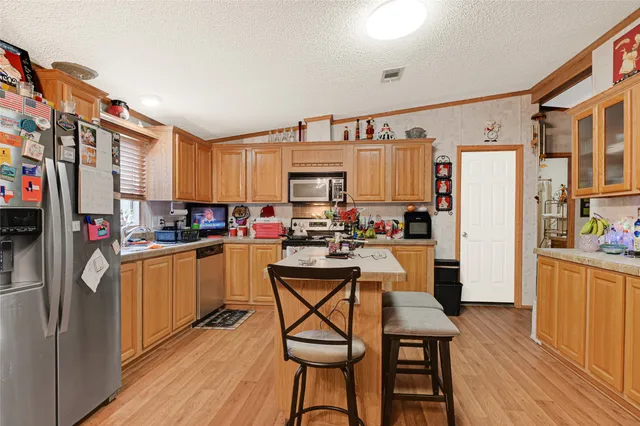 a kitchen with stainless steel appliances a refrigerator and a stove top oven