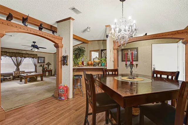 a view of a dining room with furniture and chandelier