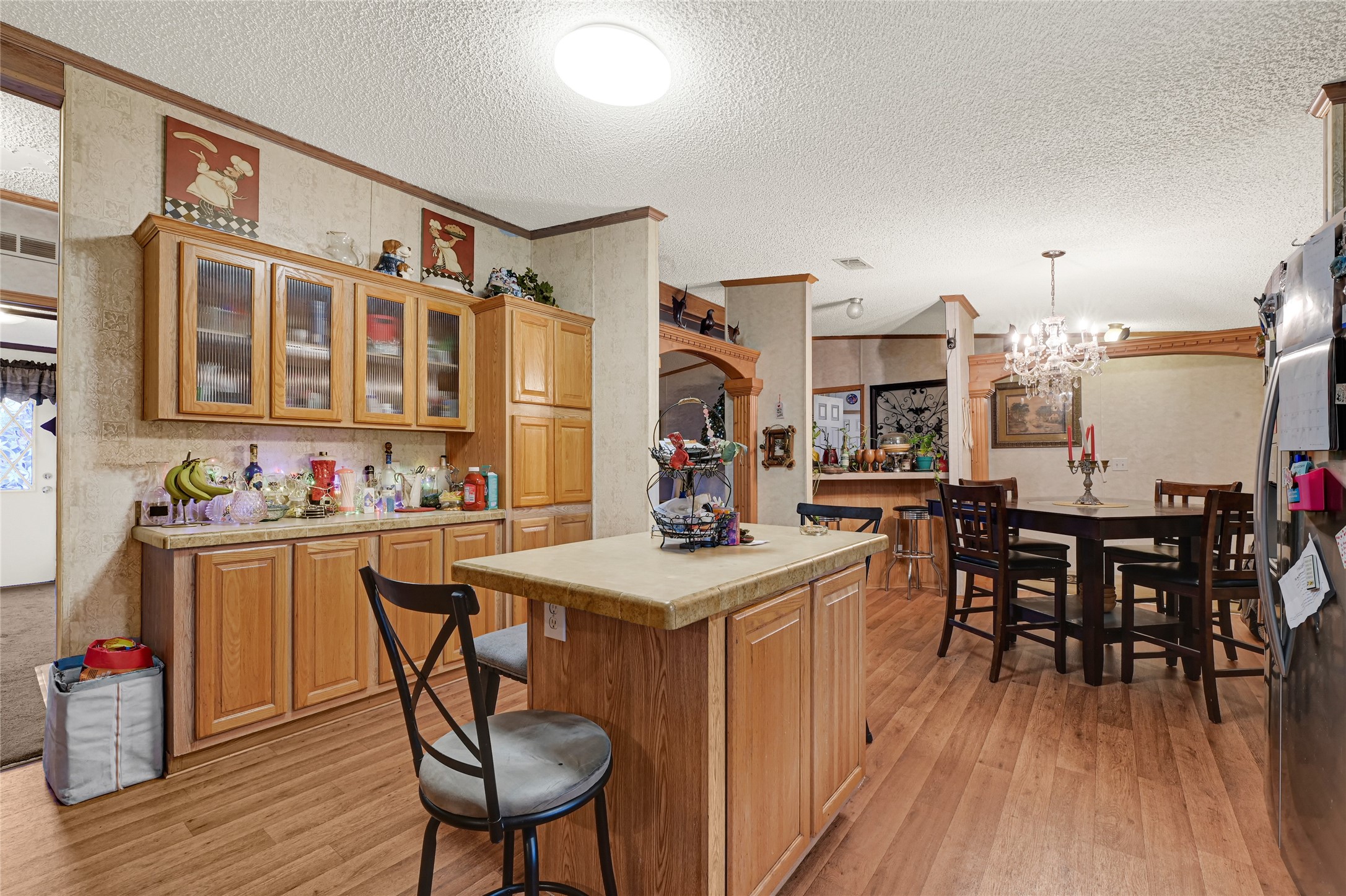 17106 Pickering Road Conroe, TX 77302 - Photo 3 of 50 a kitchen with stainless steel appliances granite countertop a stove a sink dishwasher a dining table and chairs with wooden floor