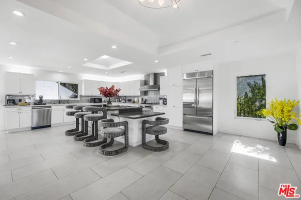 a kitchen with a sink and chairs
