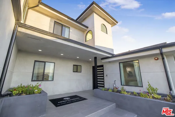a front view of a house with a garden