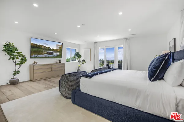 a bedroom with a large bed and a flat screen tv