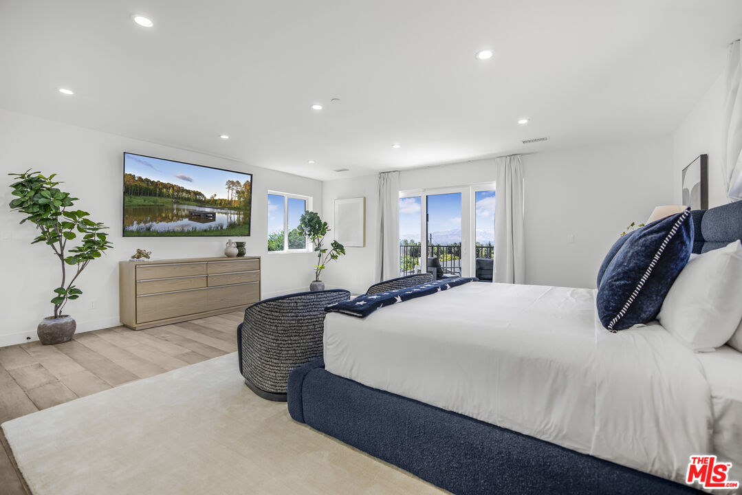 18202 Rancho Street Tarzana, CA 91356 - Photo 23 of 33 a bedroom with a large bed and a flat screen tv