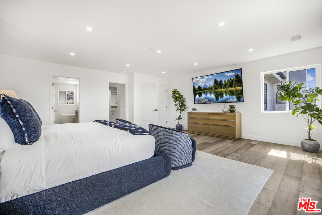 18202 Rancho Street Tarzana, CA 91356 - Photo 24 of 33 a spacious bedroom with a bed and a flat screen television