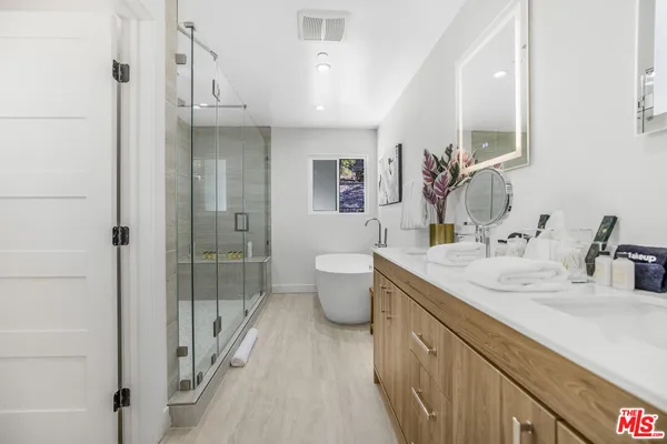 a bathroom with a double vanity sink toilet and shower