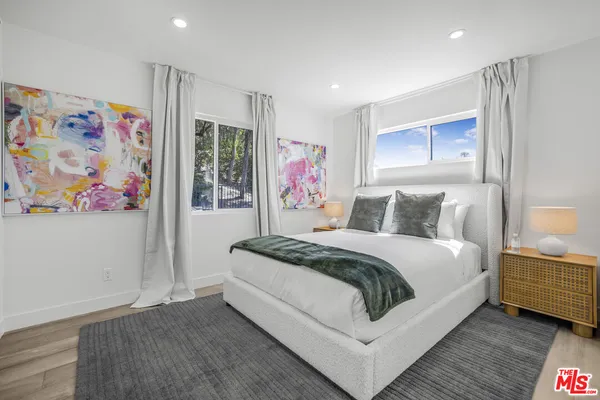 a spacious bedroom with a bed and wall painting