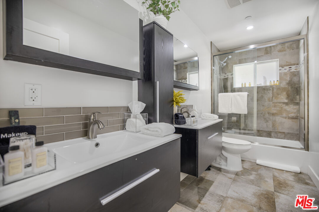 18202 Rancho Street Tarzana, CA 91356 - Photo 29 of 33 a bathroom with a sink a toilet and shower