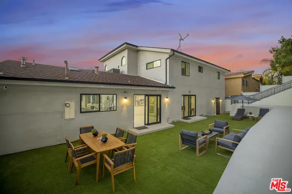 a backyard of a house with outdoor seating