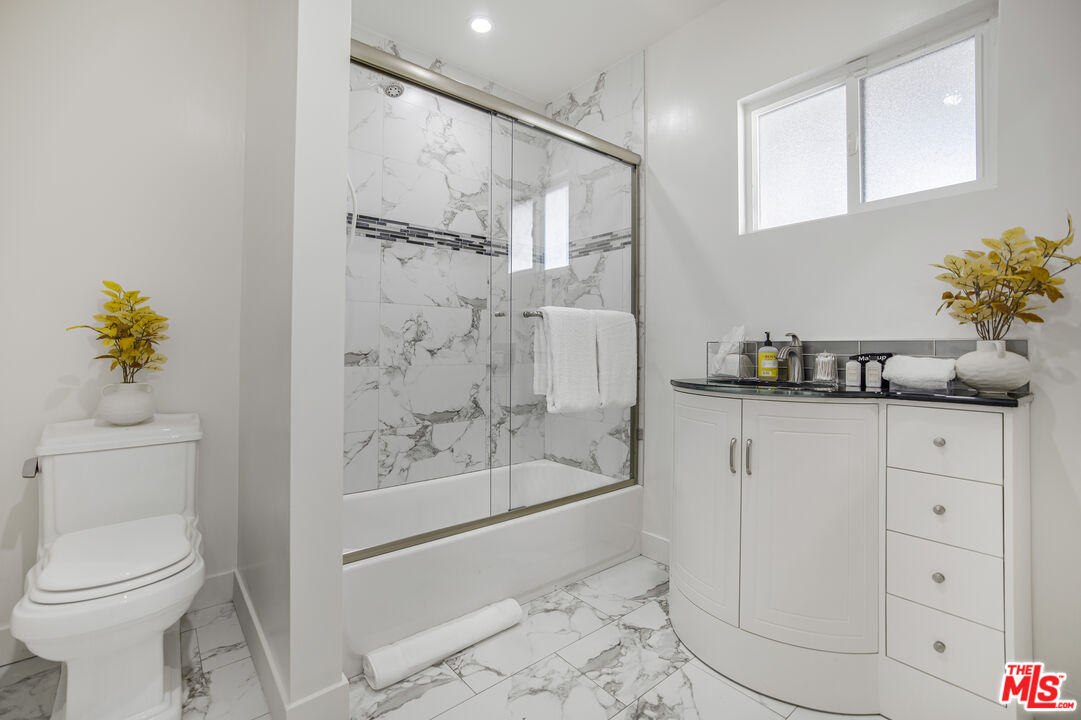 18202 Rancho Street Tarzana, CA 91356 - Photo 31 of 33 a bathroom with a granite countertop sink a toilet and shower