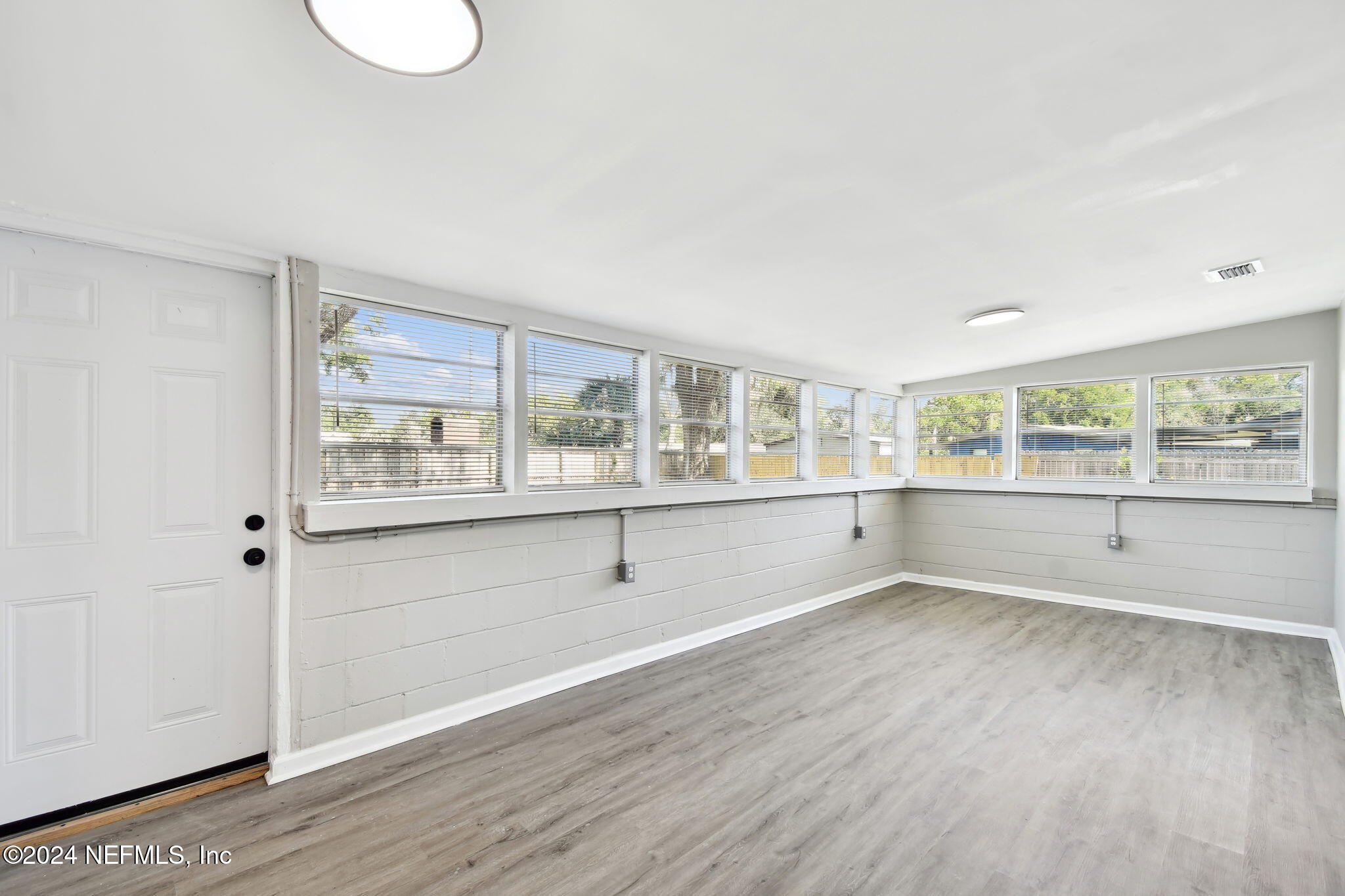 7518 Pinnacle Drive Jacksonville, FL 32221 - Photo 13 of 28 a view of an empty room with wooden floor and a window