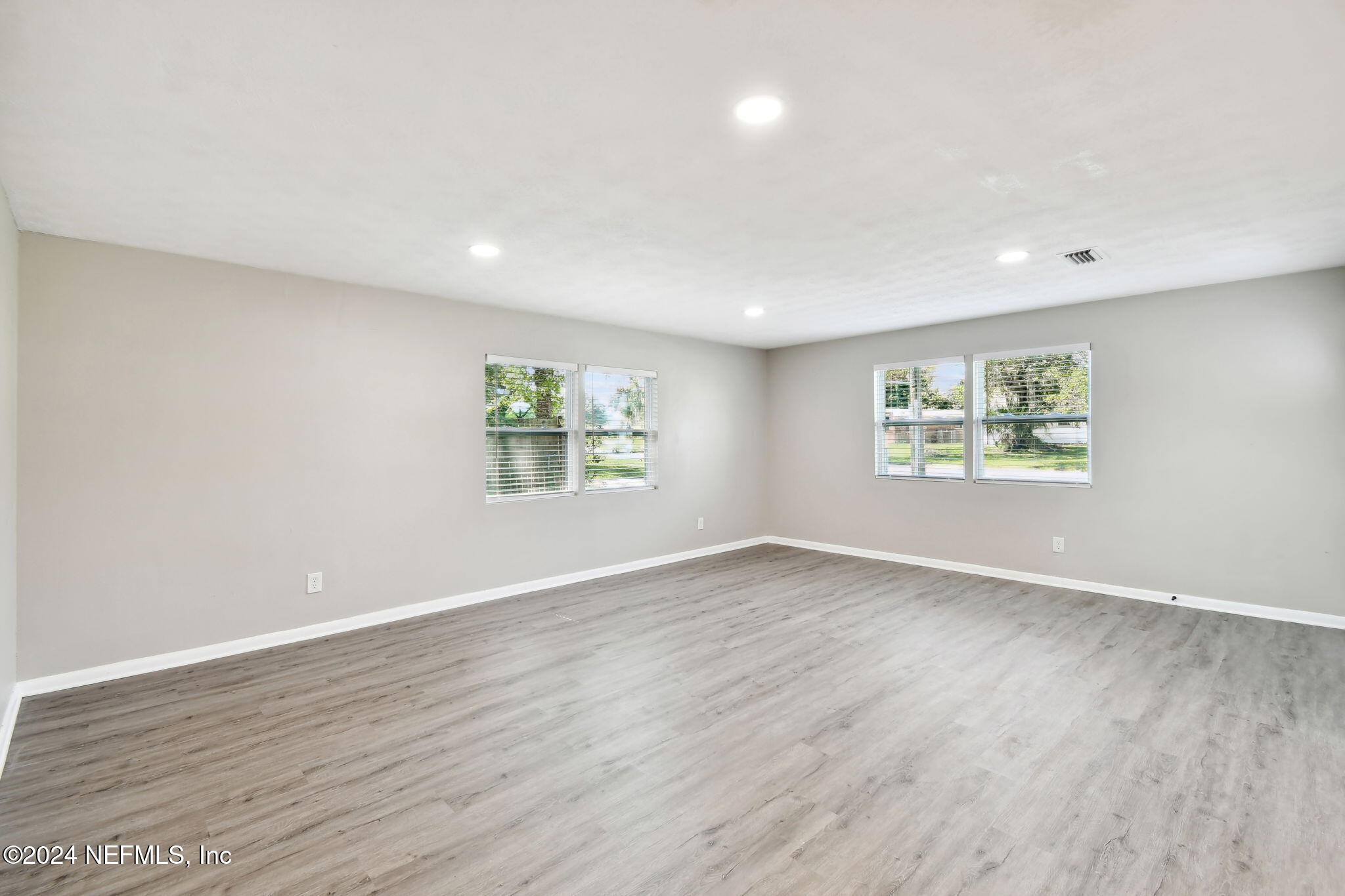 7518 Pinnacle Drive Jacksonville, FL 32221 - Photo 6 of 28 a view of an empty room with a window and wooden floor