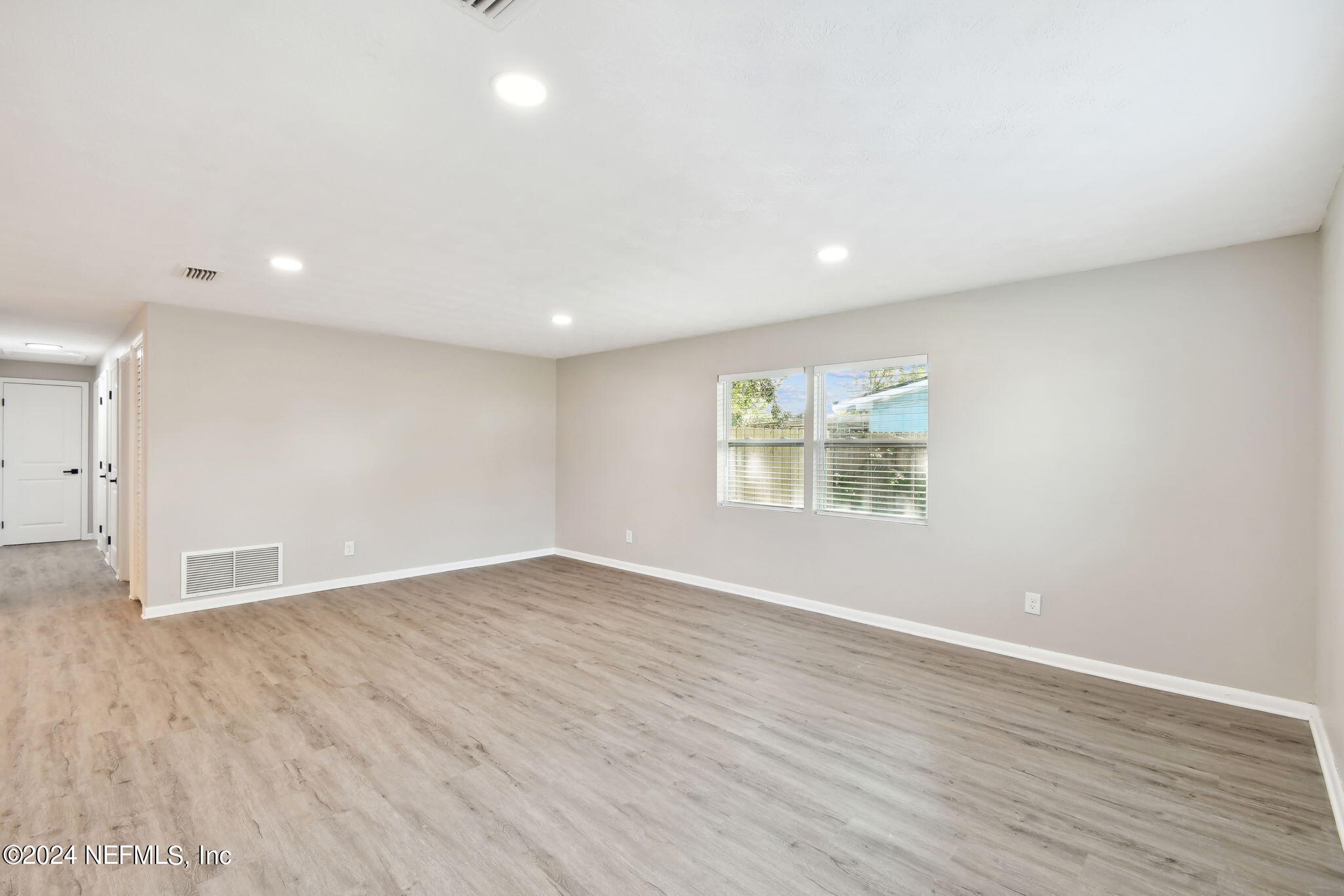7518 Pinnacle Drive Jacksonville, FL 32221 - Photo 7 of 28 a view of an empty room with wooden floor and a window
