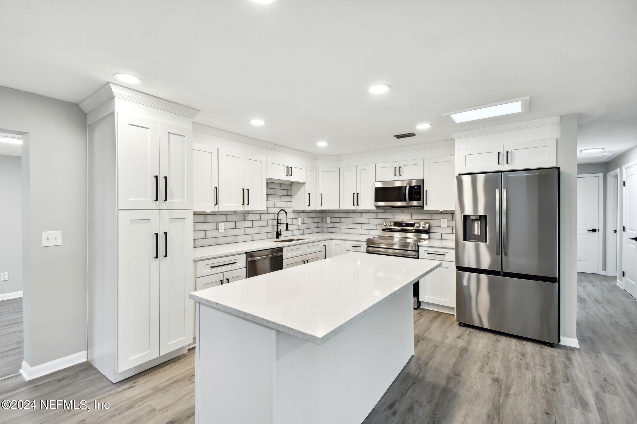 7518 Pinnacle Drive Jacksonville, FL 32221 - Photo 9 of 28 a kitchen with white cabinets and stainless steel appliances