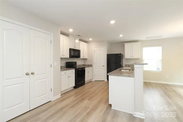 a kitchen with a sink a microwave a refrigerator and cabinets