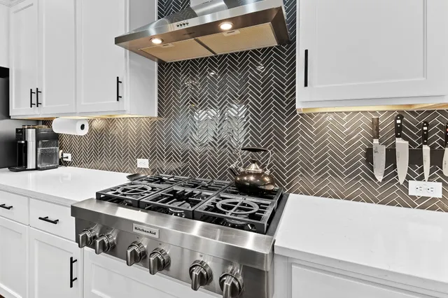 a kitchen with a stove and white cabinets