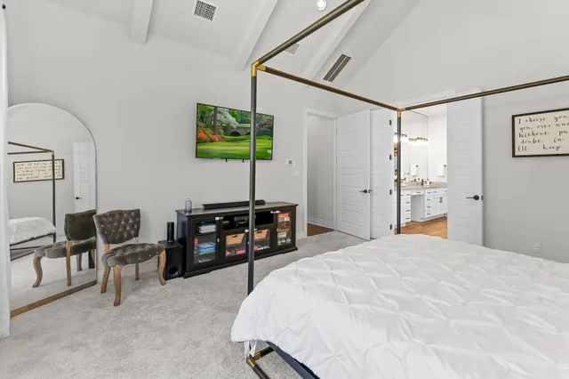 a bedroom with furniture and a flat screen tv