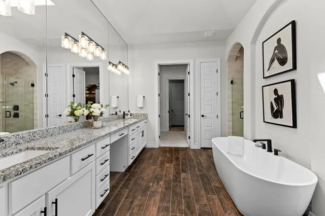 a spacious bathroom with a granite countertop tub sink and mirror