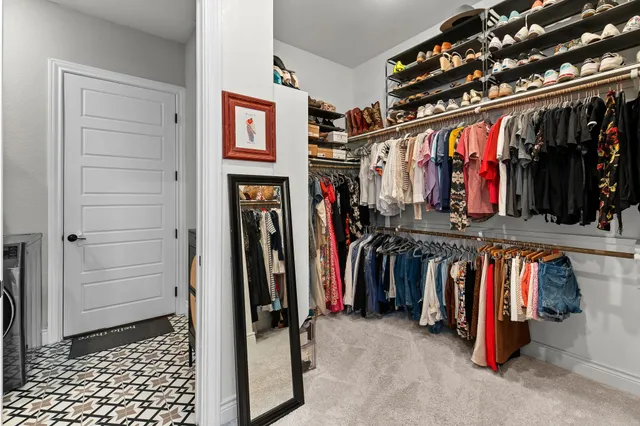 a view of walk in closet with clothes