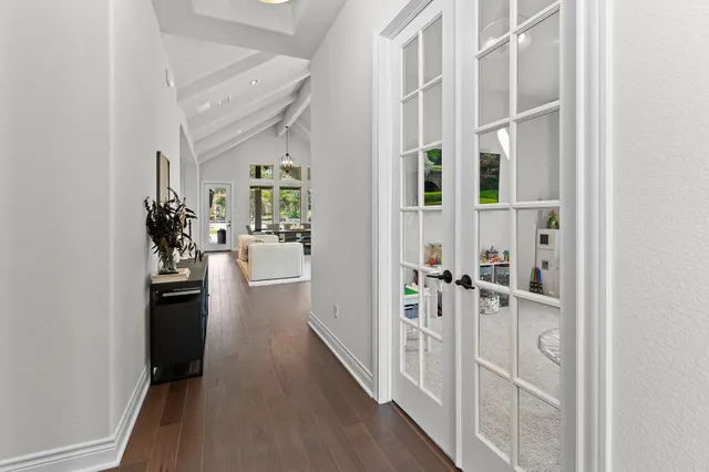 a view of a hallway with wooden floor and windows