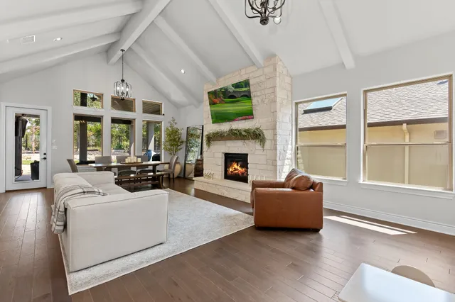 a living room with furniture large window and fireplace