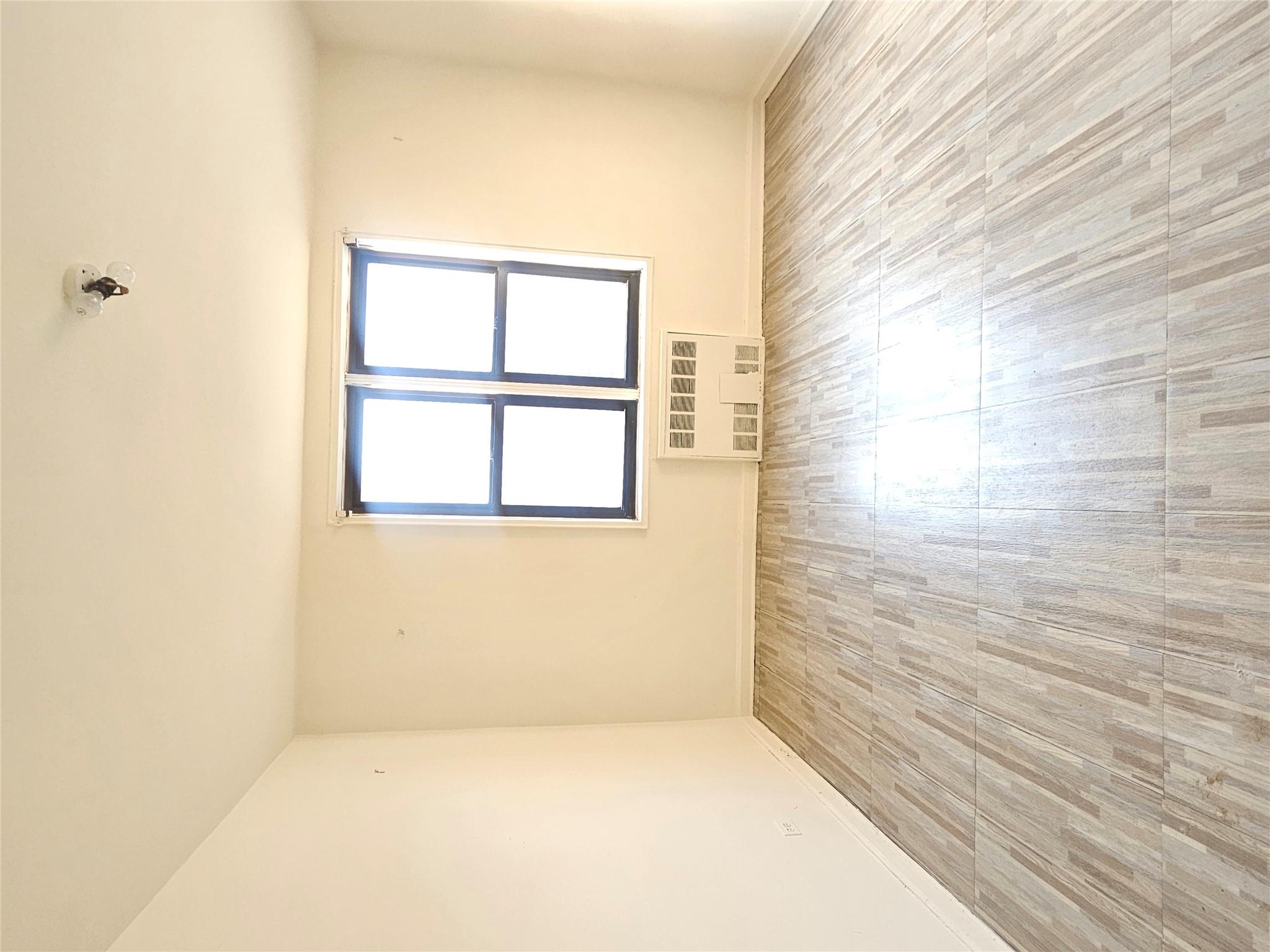 63-09 108th Street, Unit 5L Queens, NY 11375 - Photo 3 of 5 an empty room with wooden floor and windows