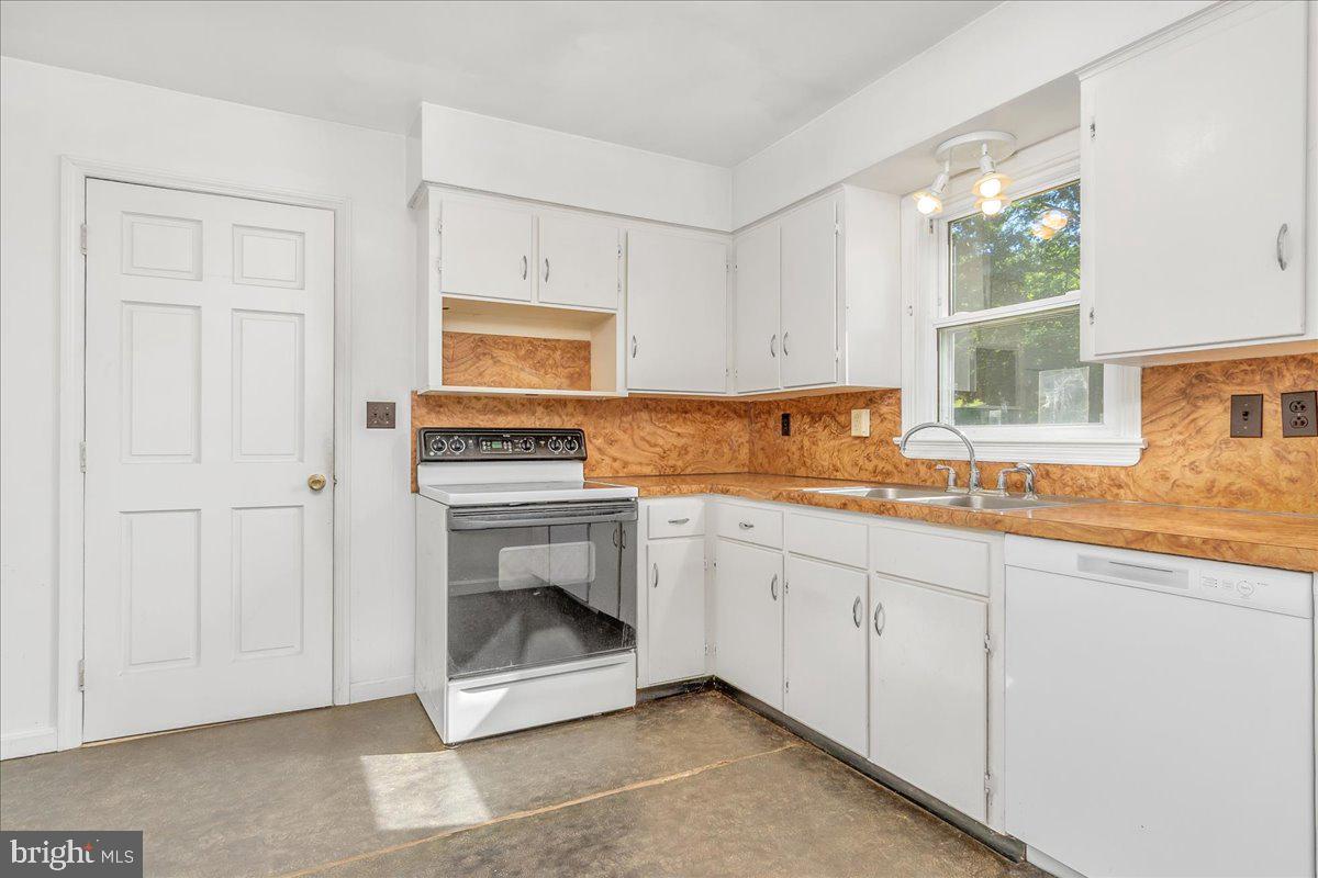 13806 Wolfsville Road Smithsburg, MD 21783 - Photo 12 of 35 a kitchen with granite countertop a stove a sink and a white cabinets