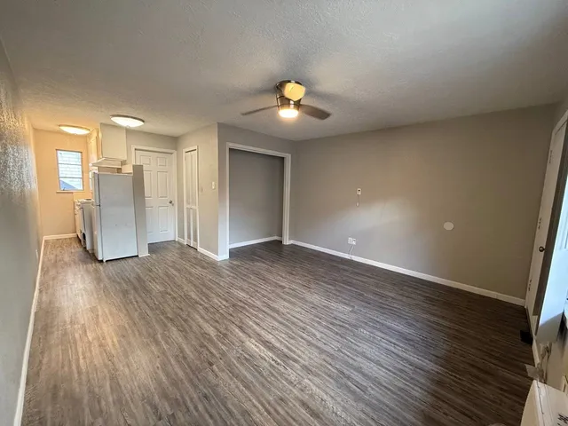a view of an empty room with wooden floor