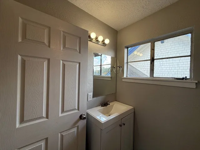 a bathroom with a sink a vanity and a window