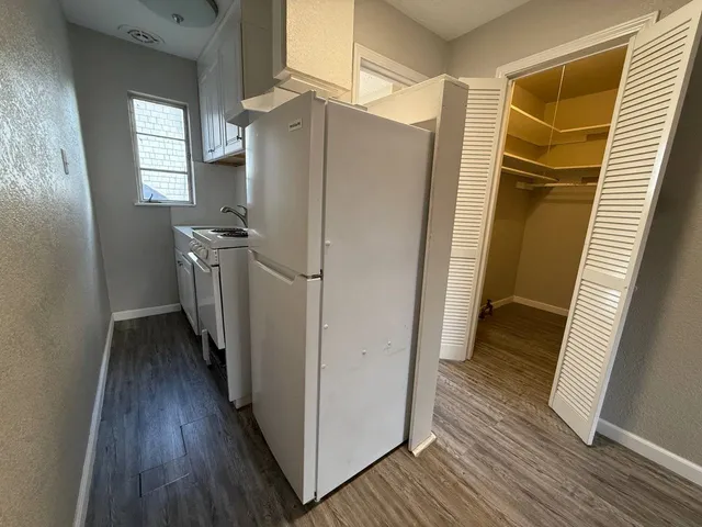 a kitchen with a refrigerator a sink and cabinets