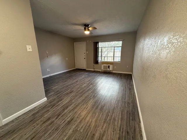 wooden floor in an empty room with a window