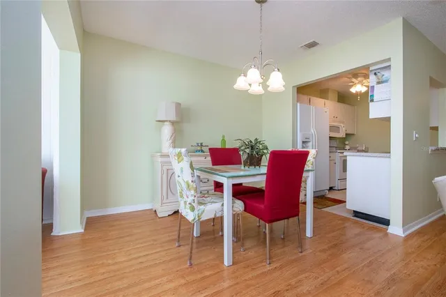 a dining room with furniture a large window and wooden floor