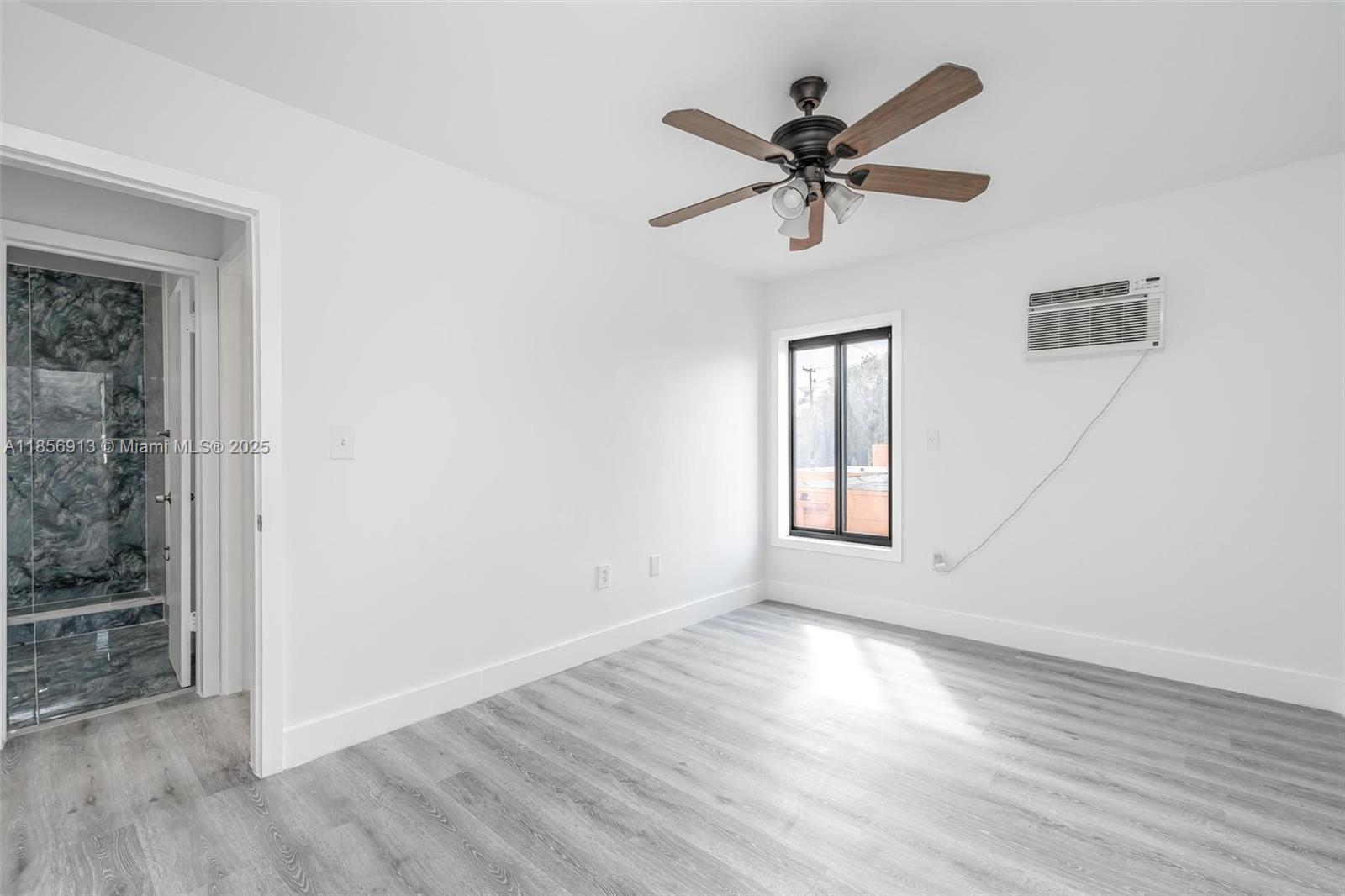 852 Southwest 1st Street, Unit 4 Miami, FL 33130 - Photo 12 of 17 a view of empty room with wooden floor and fan