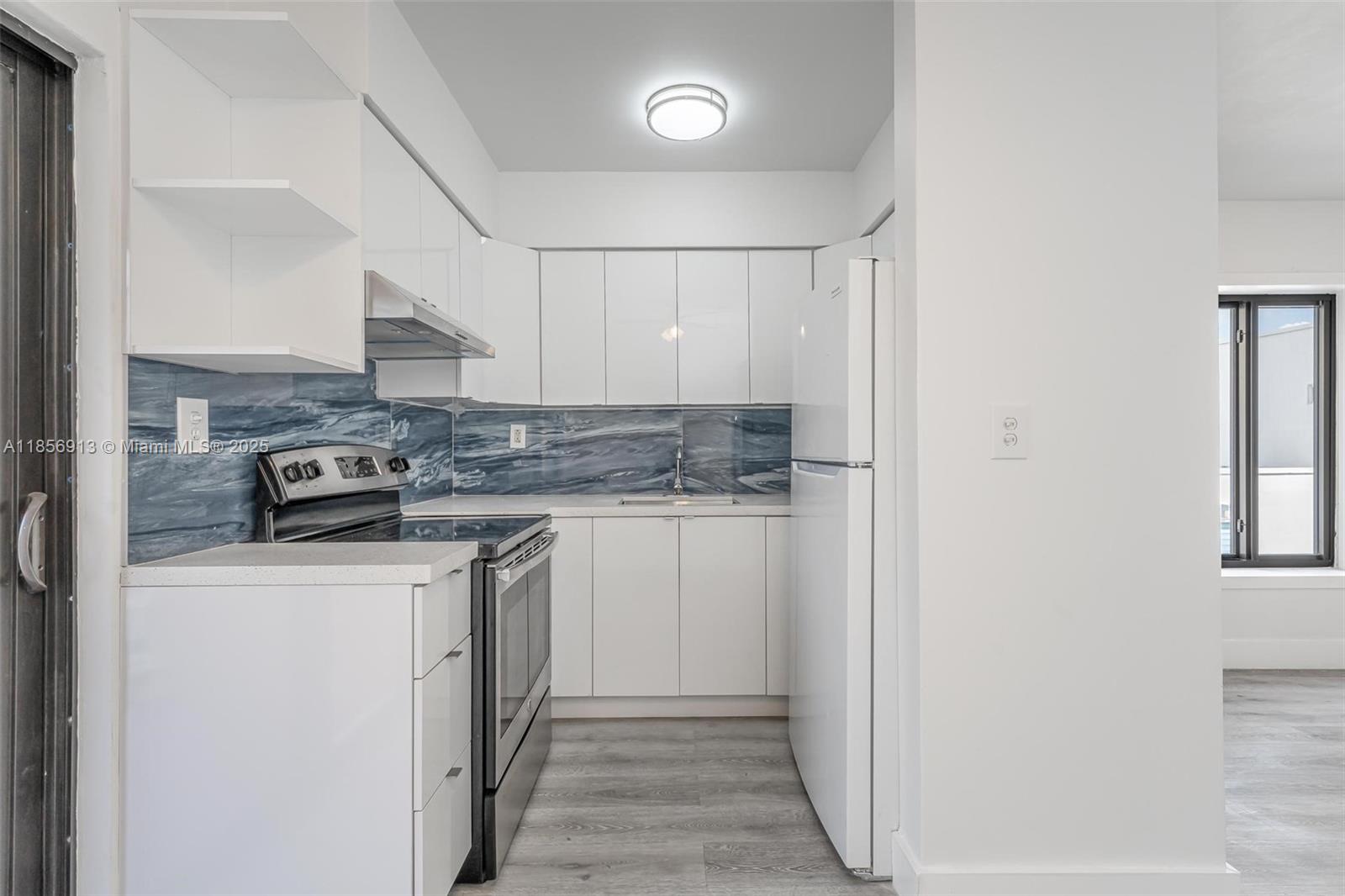 852 Southwest 1st Street, Unit 4 Miami, FL 33130 - Photo 4 of 17 a kitchen with stainless steel appliances granite countertop a stove a sink and a refrigerator