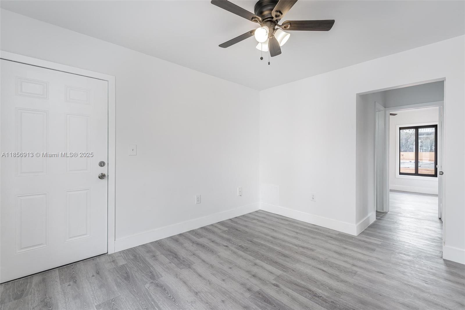 852 Southwest 1st Street, Unit 4 Miami, FL 33130 - Photo 7 of 17 an empty room with wooden floor chandelier fan and windows