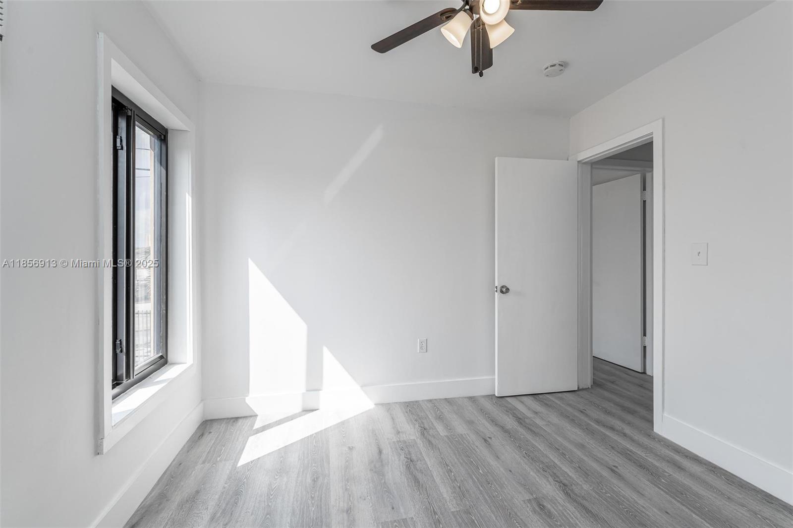 852 Southwest 1st Street, Unit 4 Miami, FL 33130 - Photo 8 of 17 wooden floor in an empty room with a window