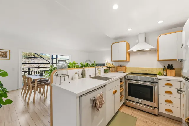 a kitchen that has a lot of cabinets in it and wooden floors