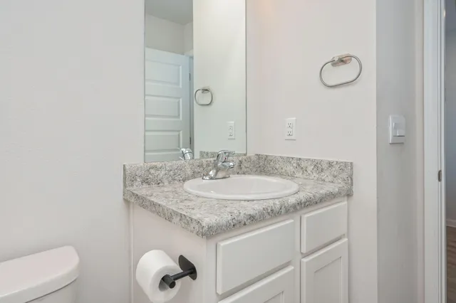 a bathroom with a granite countertop sink and a mirror