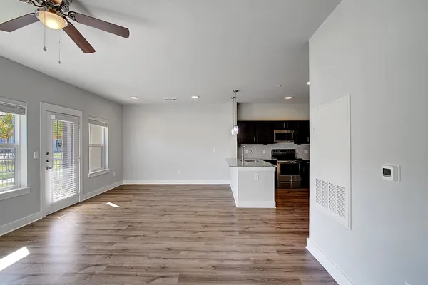 a view of kitchen with refrigerator stove and wooden floor
