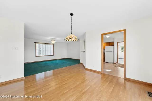 a view of empty room with wooden floor and window
