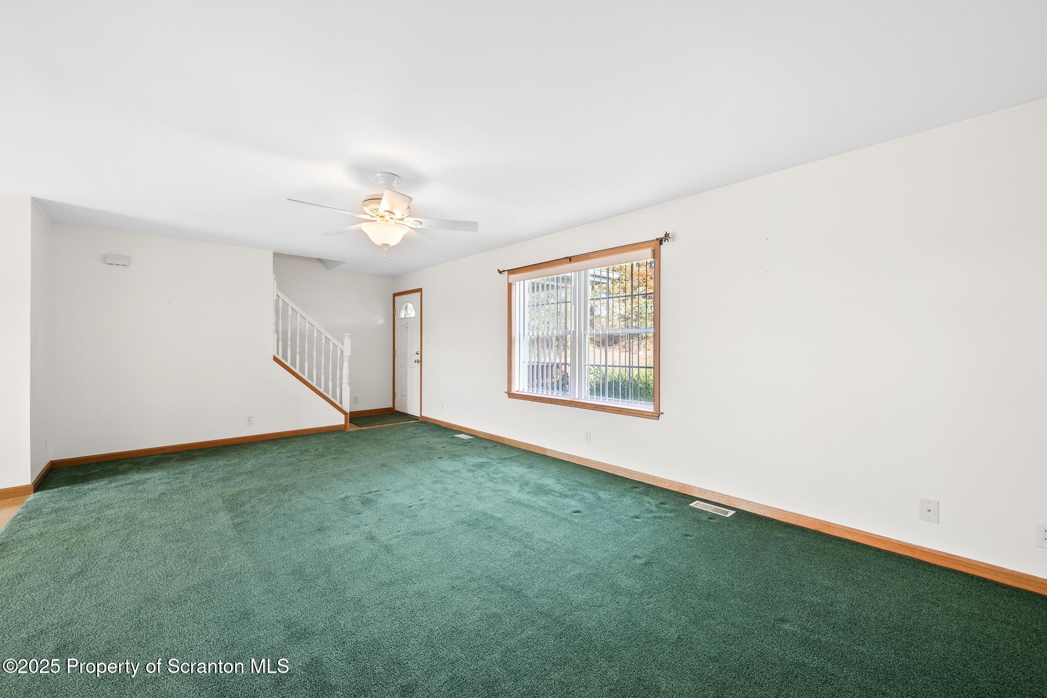 1336 Bush Road Montrose, PA 18801 - Photo 19 of 55 an empty room with a chandelier fan and windows