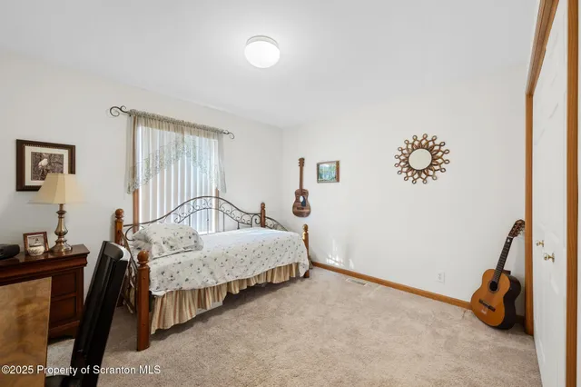 a bedroom with a bed and a painting on the wall