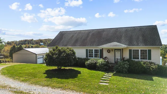 a aerial view of a house with a yard and large trees