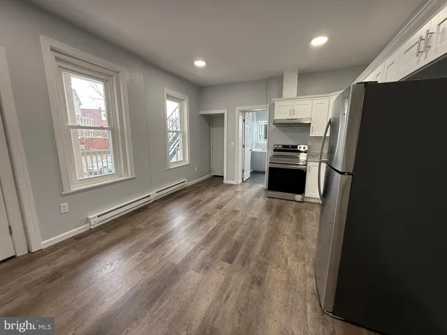 a kitchen with a refrigerator and a stove top oven