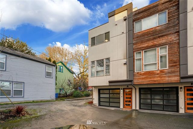 a view of a house with a yard and parking space