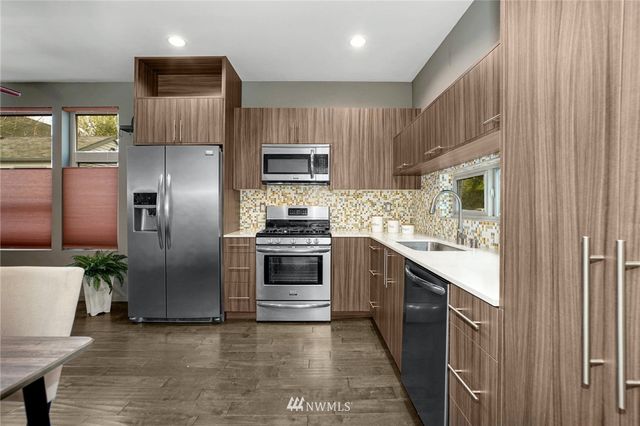 a kitchen with granite countertop a refrigerator and a stove top oven