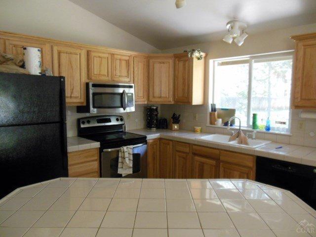 17246 Indio Road Bend, OR 97707 - Photo 5 of 21 a kitchen with a sink a counter top space cabinets and stainless steel appliances