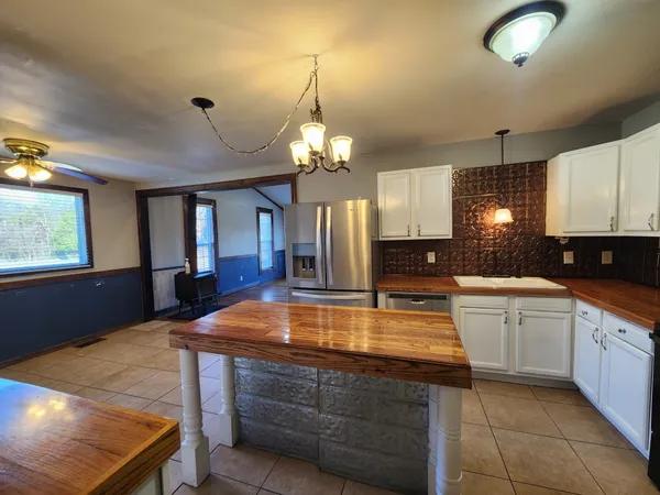 a kitchen with kitchen island granite countertop a stove a sink and a refrigerator
