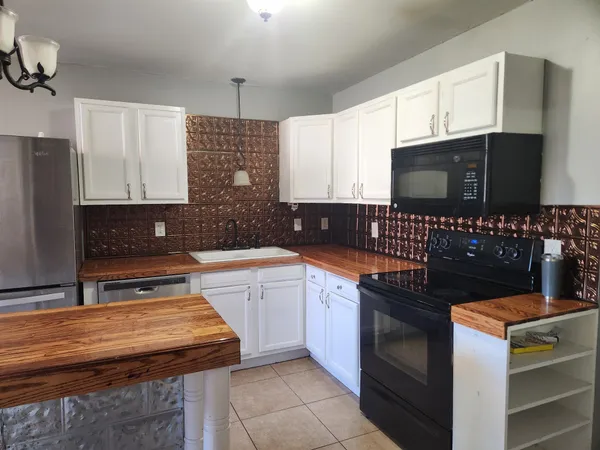 a kitchen with granite countertop a sink wooden cabinets and stainless steel appliances