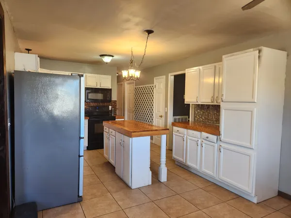 a kitchen with refrigerator and cabinets