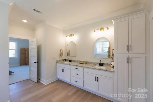 a spacious bathroom with double vanity a mirror and a sink